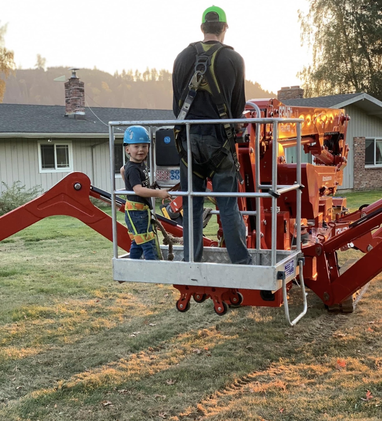 Cody Rose with his young son in the crane basket at sunset